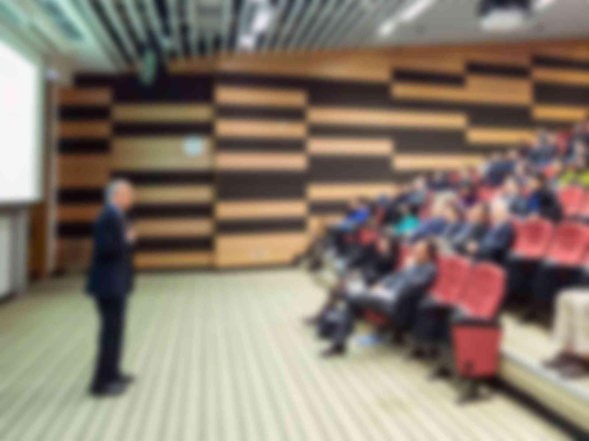 Tips for Presenting to Executives - man-addressing-crowd-in-auditorium