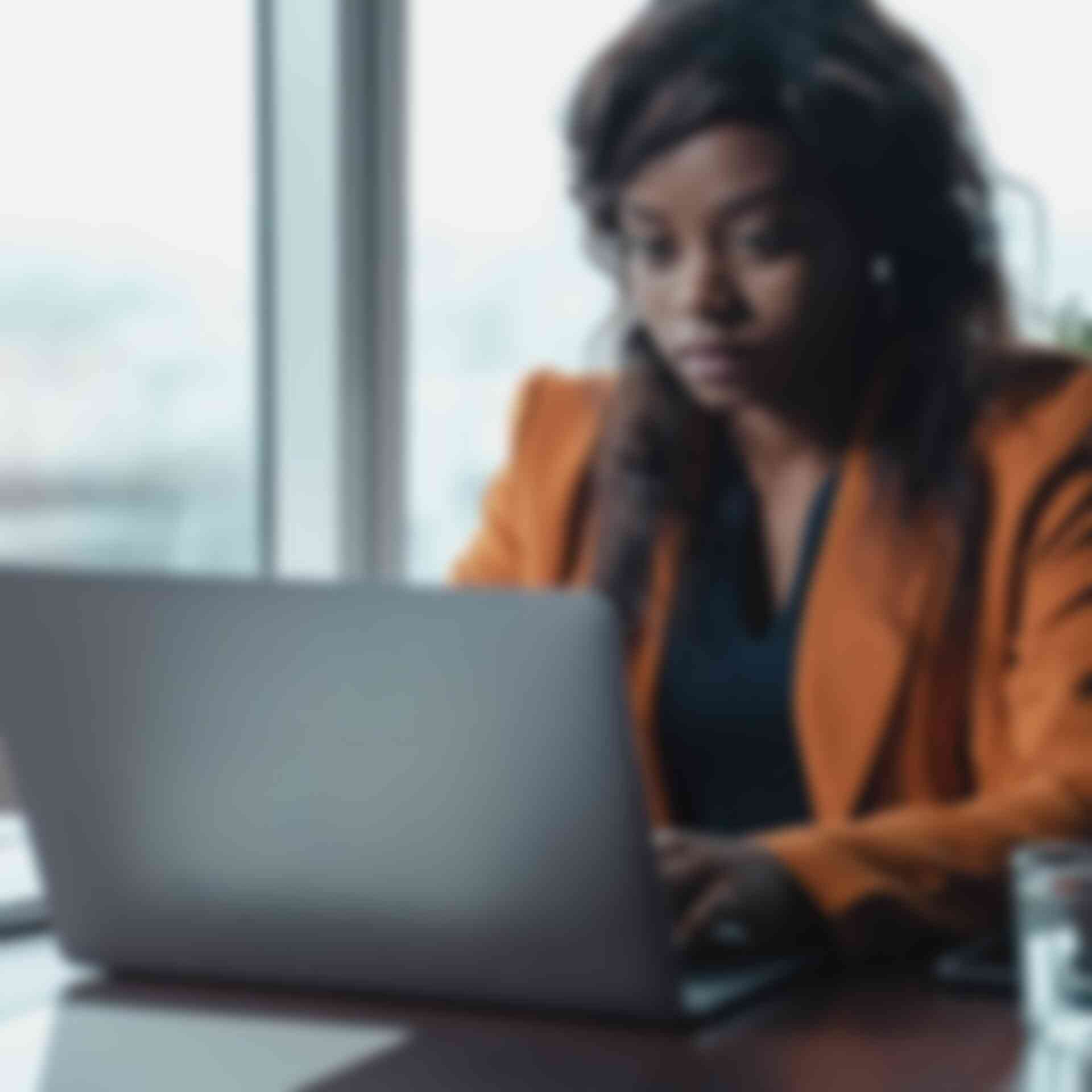 Writing Skills for Auditors - woman-with-orange-blazer-typing-on-computer